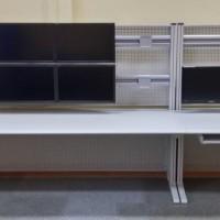 szare biurko z ośmioma monitorami 